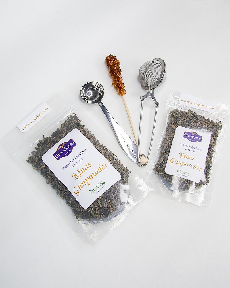 Packed gunpowder green tea in transparent doypacks with accessories tea strainer, tea spoon, and sugar stick. China Gunpowder Tea, Graudupes Classic Green Tea, Premium Loose Leaf Green Tea.