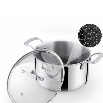 A stainless steel stockpot with a clear glass lid, shown on a white background with a black ceramic coating in a hexagon shape inside, and a small ZINOX logo on the pot.