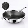 A Zinox Clad stainless steel wok with a black textured non-stick ceramic interior, shown on a clean white background with a circular inset detail of the interior honeycomb pattern.